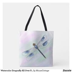 a blue dragonfly sitting on top of a white tote bag