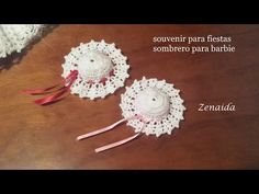 two crocheted doily hats sitting on top of a wooden table