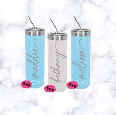 three blue and white tumblers with pink flowers in the middle on a marble background