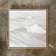 a painting hanging on the wall in front of a wooden frame with watercolor paint