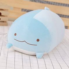 a blue whale shaped pillow sitting on top of a table