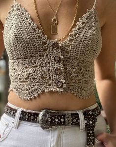 a woman wearing a crochet top and belt