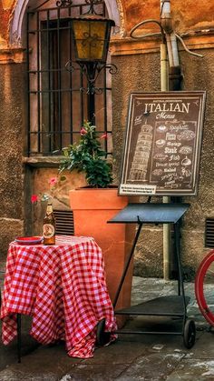 a table with a red and white checkered cloth on it next to a sign