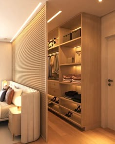 a room with a couch, closet and shoe rack in the corner on the wall