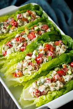 lettuce with tomatoes and chicken salad in a white dish