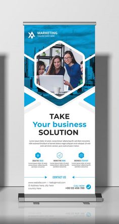 a blue and white business roll up banner with two women on laptops in the background