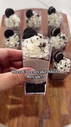 someone holding up a cupcake with oreo cheesecake shots in it