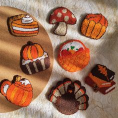 several knitted pumpkins and mushrooms on a white furnishing area next to a wooden platter