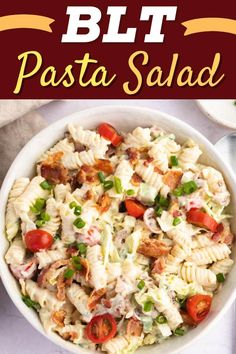 a bowl filled with pasta salad on top of a white table next to a red sign