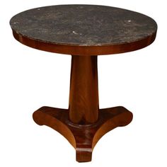 a round wooden table with black marble top