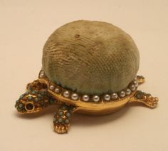 a turtle brooch with pearls on it's shell