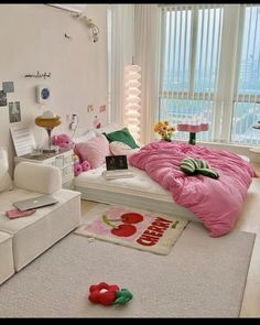 a white bedroom with pink and green decor on the bed, couches and rugs