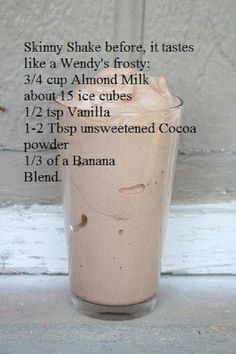 a tall glass filled with chocolate milkshake and ingredients to make it into a smoothie