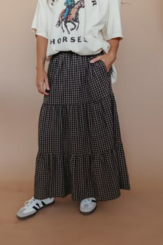 Take a spin in the THE ANNMARIE MAXI SKIRT IN BLACK GINGHAM! This tiered maxi skirt features a classic black gingham print that is both strong and soft, making it perfect for any occasion. You'll love the playful style and flattering fit of this skirt. Paired with THE HOLD YOUR HORSES GRAPHIC TEE IN IVORY and THE LOS ANGELES BASEBALL HAT IN ROYAL BLUE. Elastic waistband Tiered Back gingham print Maxi length 100% cotton Runs true to size. Small (0-4), Medium (4-8), Large (8-12), X-Large (12-14). Checkered Maxi Skirt, Fan Skirt, Hold Your Horses, Black Gingham, Gingham Skirt, Playful Style, Tiered Maxi Skirt, Exclusive Clothing, Bow Blouse