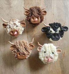 cupcakes made to look like farm animals are sitting on a wooden table top