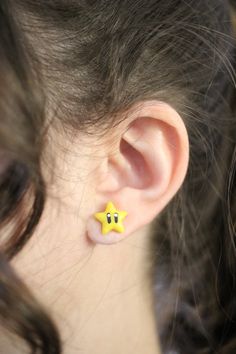 These star-shaped Mario earrings are perfect for video game enthusiasts. Handcrafted with polymer clay, the details are painted and coated with a layer of varnish. Details may differ slightly from the picture, since all earrings are handmade. These Mario star earrings are perfect for video game lovers. Handmade in polymer clay, the details are painted and covered with a layer of varnish. Some details may be slightly different from the item photo since each earring is handmade. Mario Earrings, Mario Star, Earring Video, Game Lovers, Polymer Clay Charms, Mario Kart, Clay Charms, Holiday Diy, Jewelry Companies