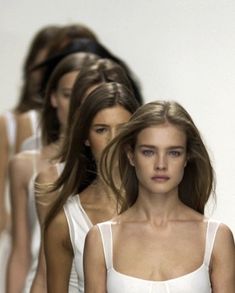 models walking down the runway in white dresses