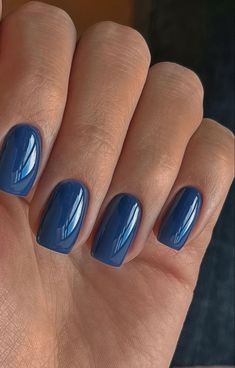 a woman's hand with blue nail polish on her nails and the tip of her finger