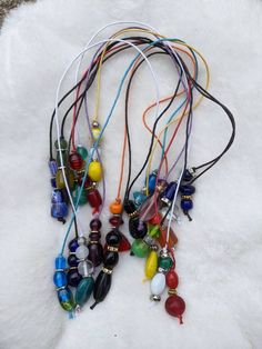 multicolored necklaces are laid out on a white furnishing with beads