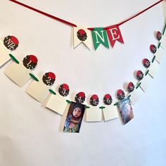 a red and green banner with pictures hanging from it's sides on a white wall