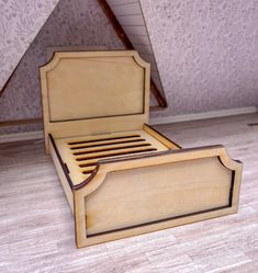 a wooden bed frame sitting on top of a hard wood floor next to a wall