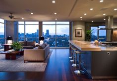 a living room filled with furniture and lots of windows next to a counter top oven