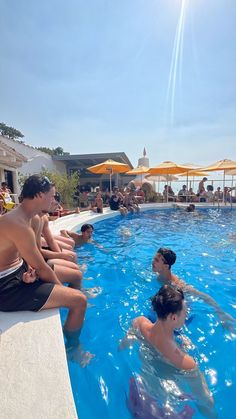 several people are sitting in the pool and one person is on his knees looking at something