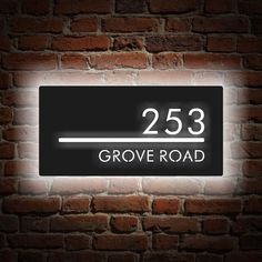 a brick wall with a black and white sign that reads 25 grove road on it