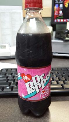 a bottle of soda sitting on top of a desk