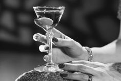 a woman holding a martini glass in her hand