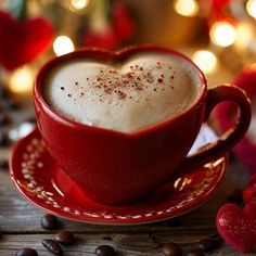 a red cup filled with coffee sitting on top of a saucer