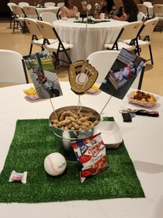 a baseball themed centerpiece sits on top of a table with snacks and candies