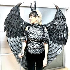 a woman wearing an animal print top and black wings