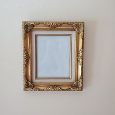 an empty gold frame hanging on the wall