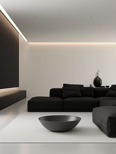 a modern living room with black couches and a large bowl on the coffee table