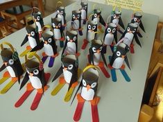 a group of penguins made out of construction paper on top of a table with scissors