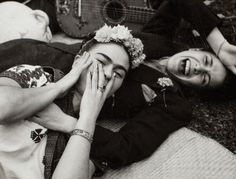 black and white photograph of two women laying on the ground with guitars behind them,