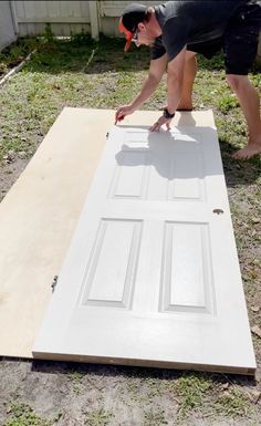 a man working on an unfinished door outside