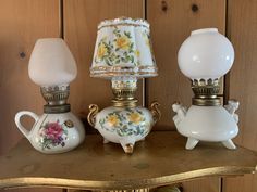 three teapots and a lamp on a table