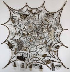 an intricate metal wall hanging with many different types of decorations on the outside and inside