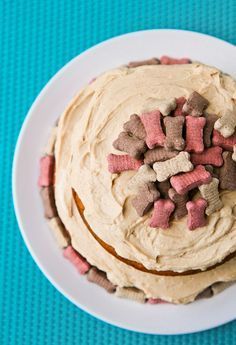 a white plate topped with two cakes covered in frosting and dog biscuits