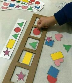 a child is cutting out shapes from cardboard