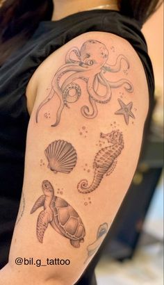 an octopus, seahorse, and turtle tattoo on a woman's arm