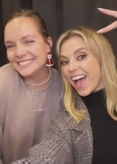 two women are posing for the camera with their hands in the air