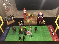 toy figurines on a football field with santa clause and other sports related items