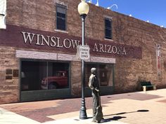 a statue is standing in front of a building with a street light on the corner