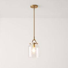 a light fixture hanging from the ceiling in a room with white walls and flooring