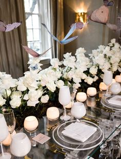 the table is set with white flowers and candles