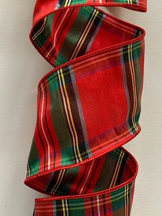 a red and green plaid ribbon on a white wall