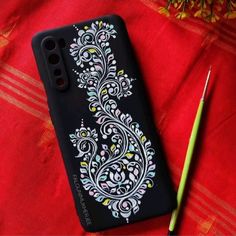 a phone case with an intricate design on it next to a green pencil and flower arrangement